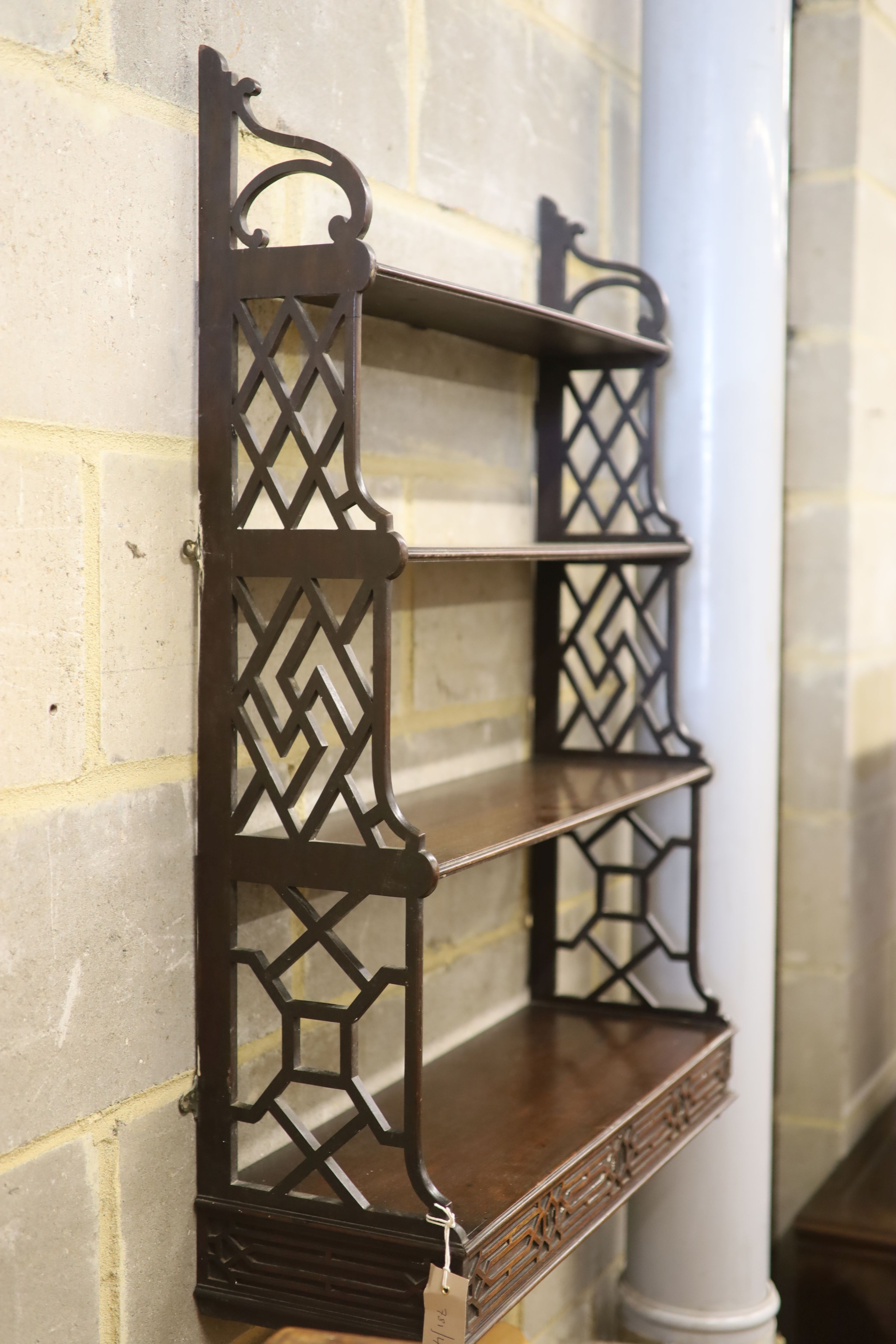 A George III mahogany fret cut four tier wall bracket, width 64cm, depth 22cm, height 94cm